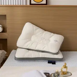 Oreiller ergonomique posé sur un lit