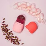 Sur fond rose, on voit un appareile n silicone qui ressemble à un déodorant, mais c'est un glaçon qui en ressort.