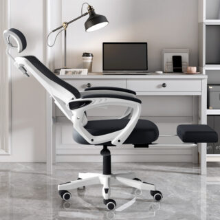 Chaise de bureau ergonomique blanche et noire inclinée devant une table de bureau avec un ordinateur portable et une lampe noire posés dessus