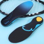 Sur fond bleu, on voit une paire de semelles antidouleur posées sur une raquette de tennis.