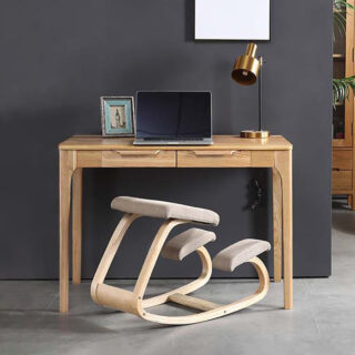 tabouret à repose genou devant un bureau en bois avec un ordinateur portable posé dessus