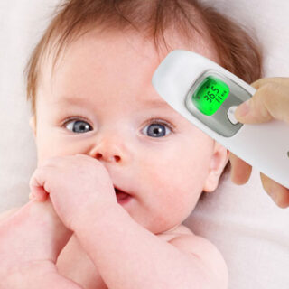 Photo d'un thermomètre numérique à infrarouge prenant la température sur la tête d'un bébé