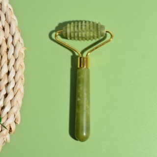 Photo représentant le rouleau de massage à micro aiguilles en pierre de jade sur un fond vert