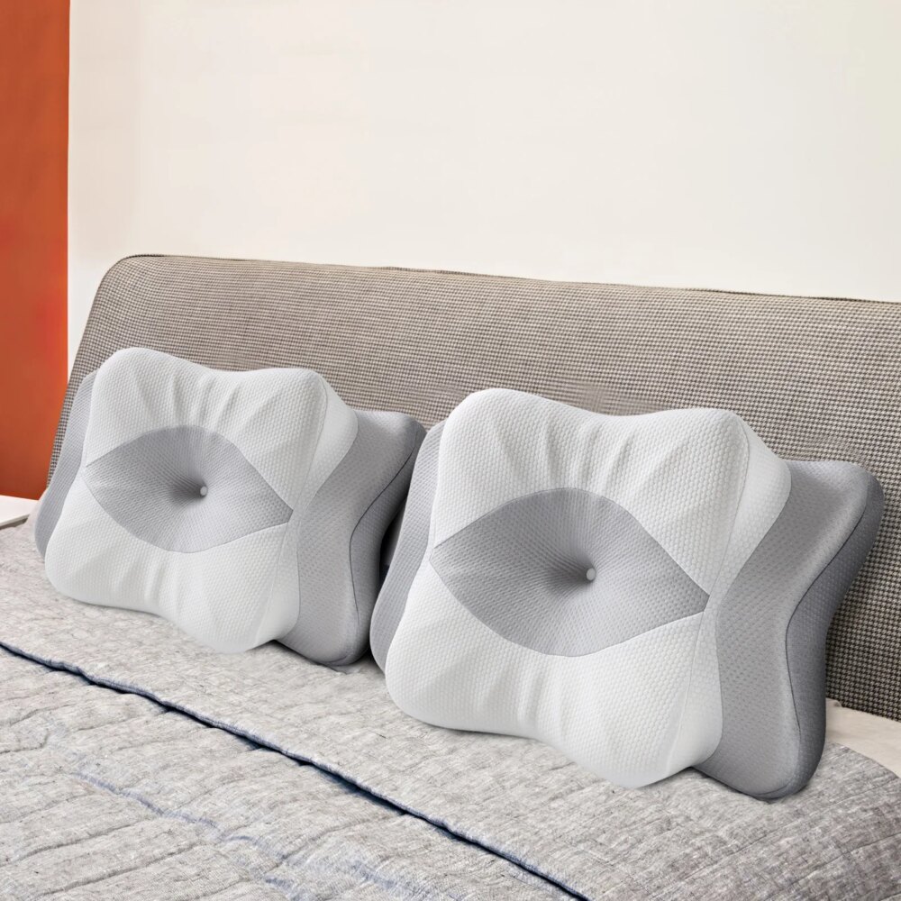 Lit avec deux oreillers ergonomique gris et blanc, avec un creux pour la tête au centre.