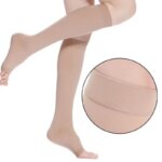 Mannequin portant une paire de chaussette de compression, beige, haute jusqu'au genou, à bout ouvert pour les orteils. Une bulle montre la bande élastique près du genou.