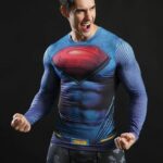 Mannequin homme portant un t-shirt compression bleu à manches longues, avec le logo de Super-Man. Sur un fond noir.