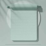 Tapis de yoga vert clair, à moitié enroulé sur une barre. Le fond est vert également.