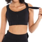 Femme portant une brassière de sport noire, avec sangles réglables et fermeture éclair sur l'avant.