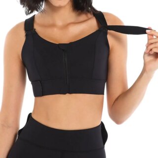 Femme portant une brassière de sport noire, avec sangles réglables et fermeture éclair sur l'avant.