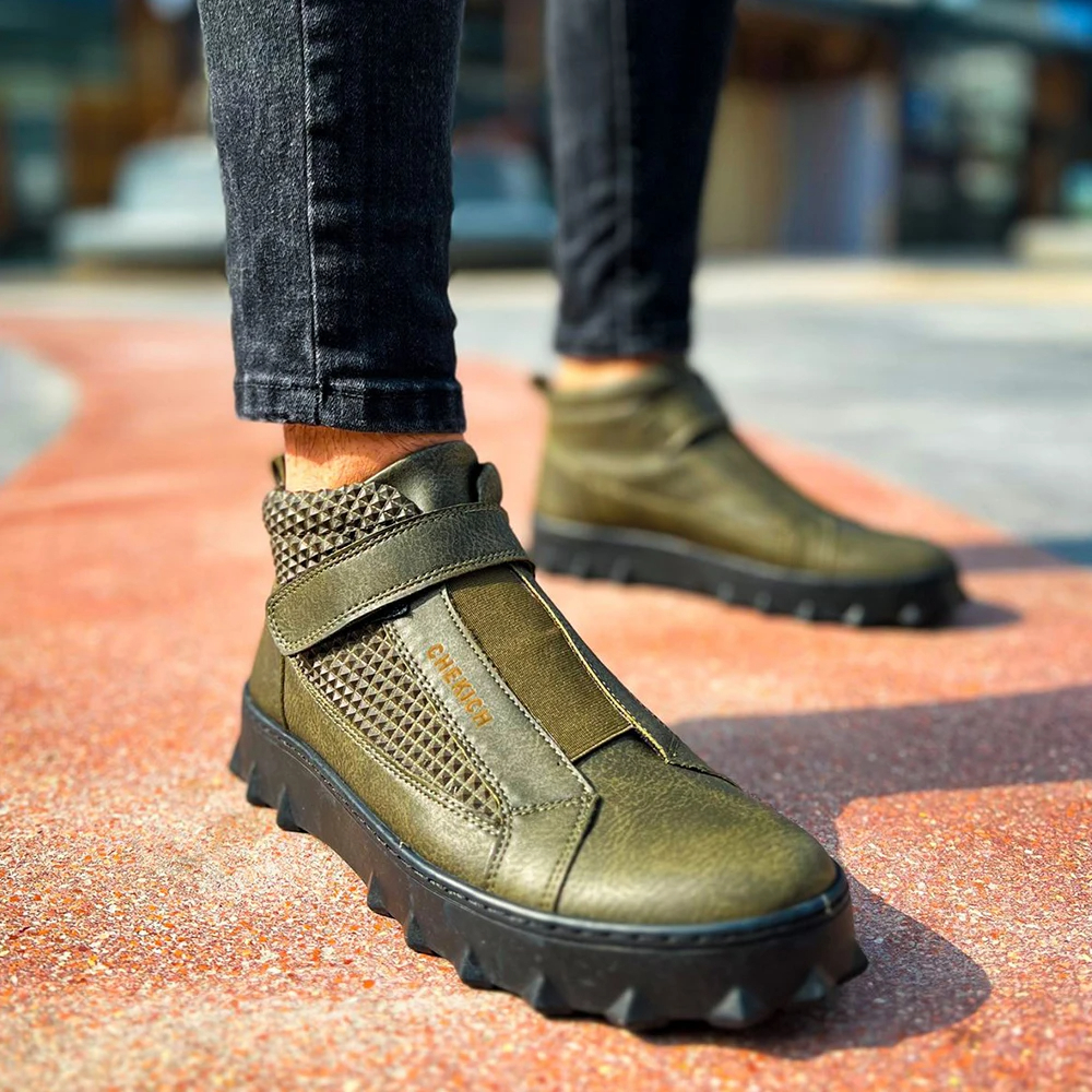 Paire de chaussures orthopédiques homme vertes en simili cuir à fermeture élastique sur un homme en jean