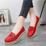 Mannequin portant une paire de chaussures mocassins orthopédique rouges, pour femme à semelle compensées. On ne voit que ses pieds.