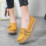 Mannequin portant une paire de chaussures mocassins orthopédique jaune moutarde, pour femme à semelle compensées. On ne voit que ses pieds.