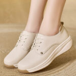 Mannequin portant une paire de chaussures orthopédique beiges, pour femme à semelle compensées. On ne voit que ses pieds.