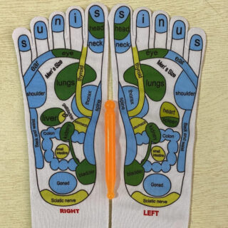 Chaussettes de réflexologie pour cibler les points d'acupression, avec stylo d'acupression orange, sur un fond beige.