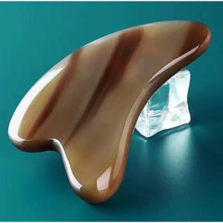 Pierre de massage visage lisse et ergonomique sur fond vert